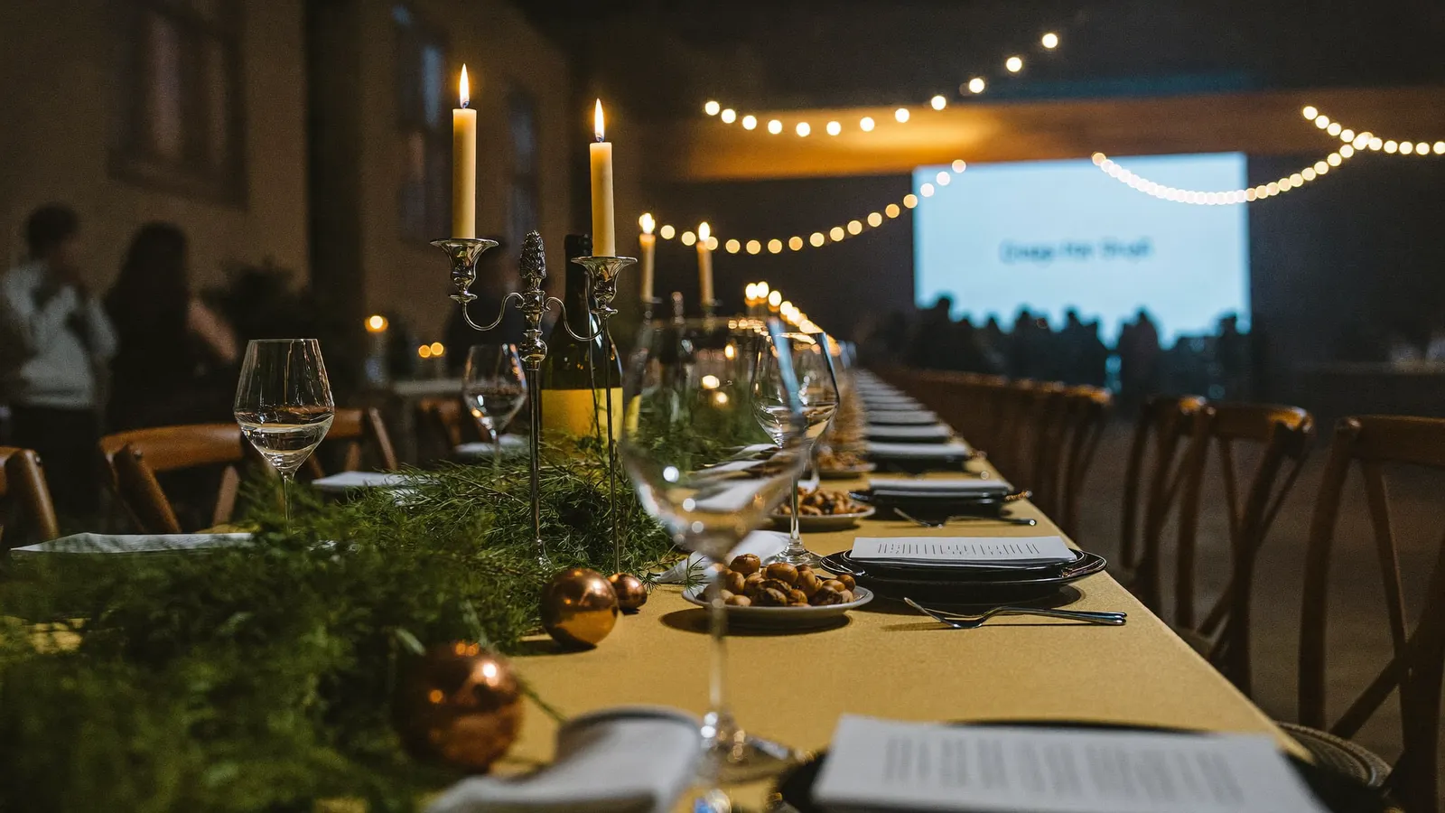 Festlich gedeckte Tafel mit Kerzen und Lichterketten bei einer Firmenfeier